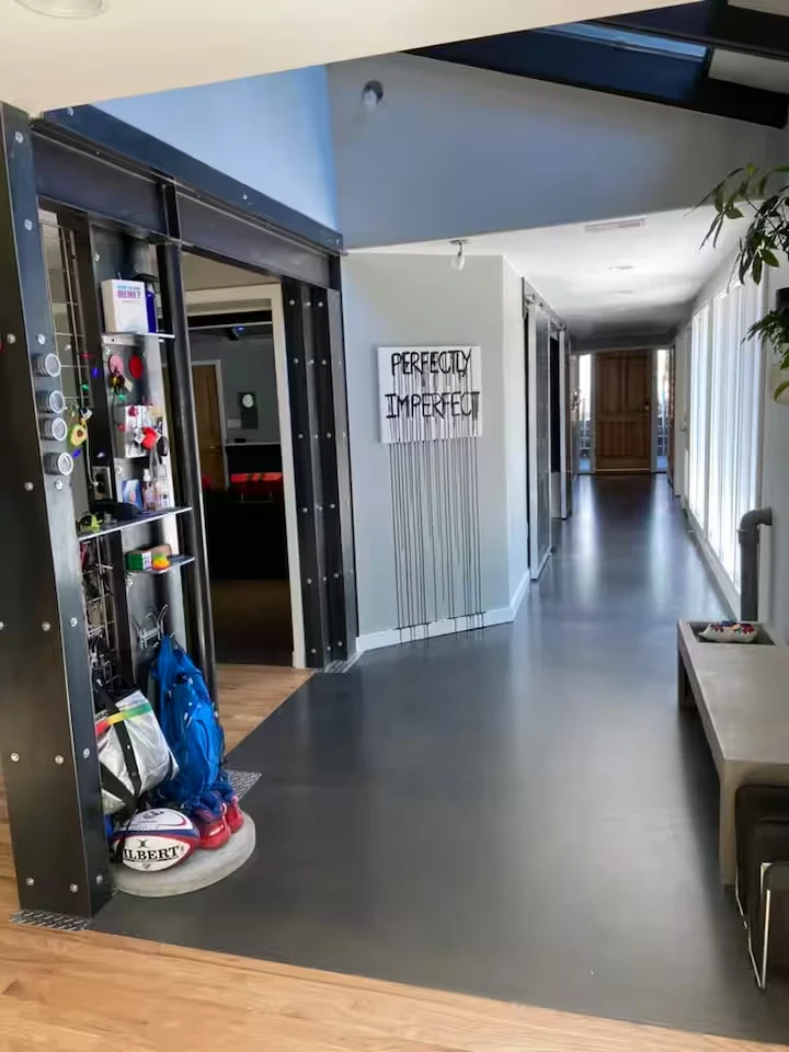 Steel-framed interior hallway with display shelves, windows and Perfectly Imperfect wall artwork