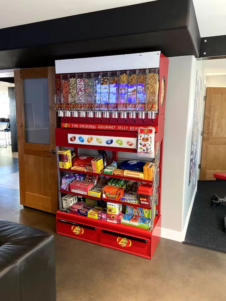 Red Jelly Belly dispenser and shelves stocked with assorted candy in the cinema