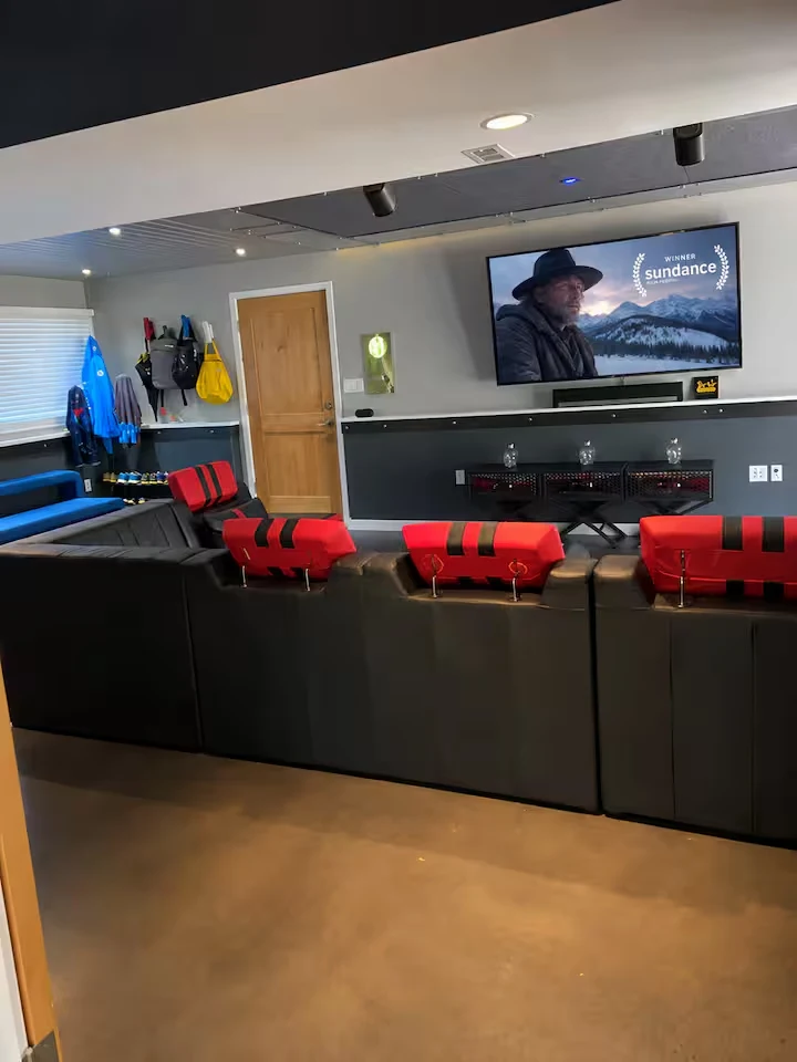 Rear view of theater seating facing a wall-mounted screen and soundbar