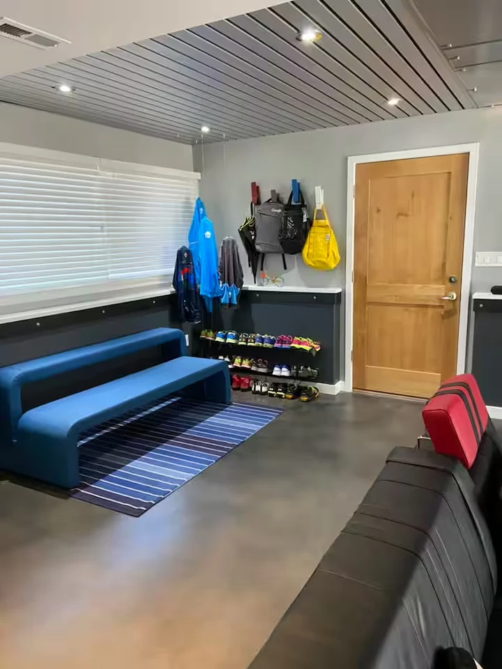 Blue bench seating and outdoor gear storage beside the garage entrance