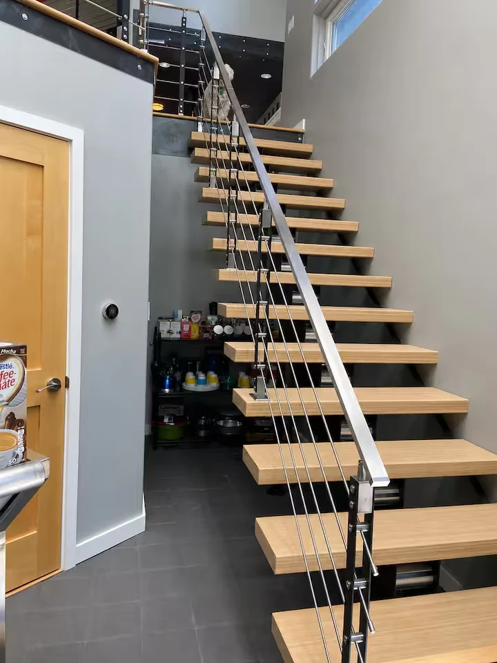 Open timber staircase with black steel supports and cable railing leading to the sunroom